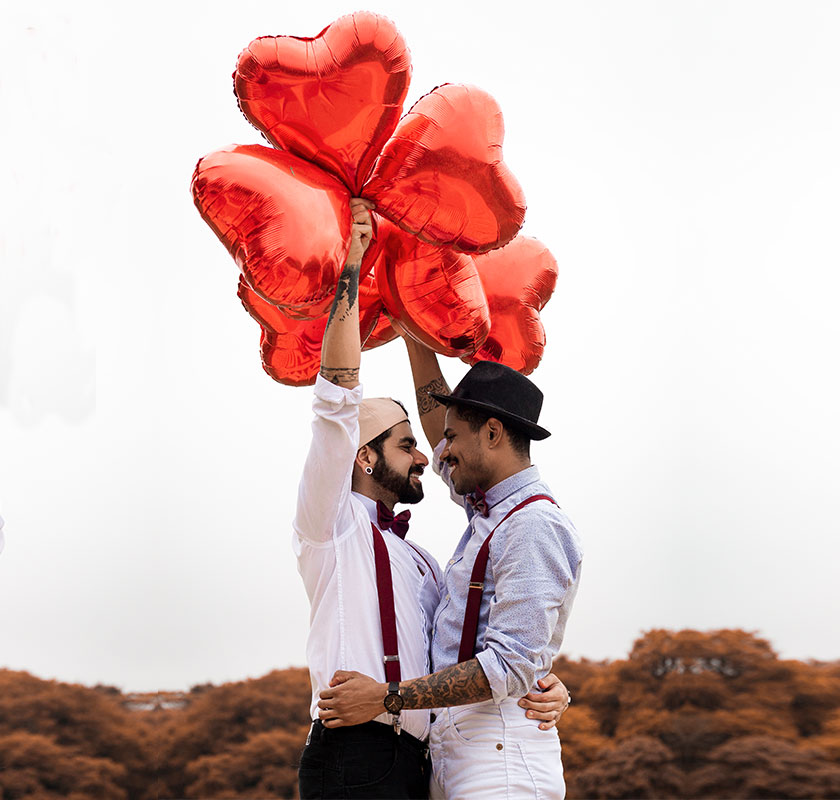 two-men-holding-red-heart-balloons